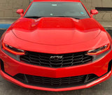 Front end of a red Chevrolet Camaro with red headlight DRLs.