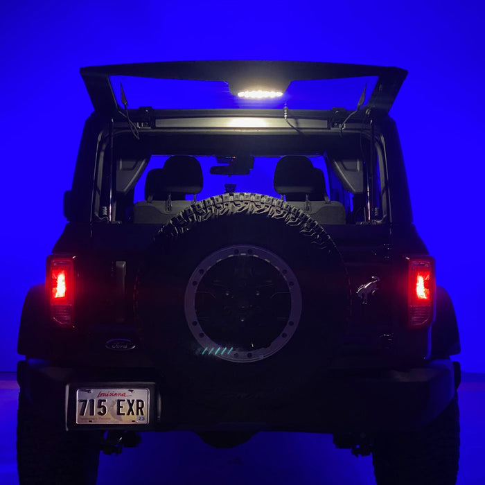 Rear view of Ford Bronco with trunk open and cargo light on.