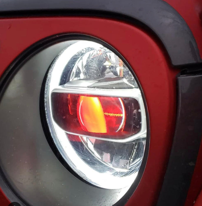 Close-up of a Jeep Wrangler headlight with amber "Demon Eye" Projector.