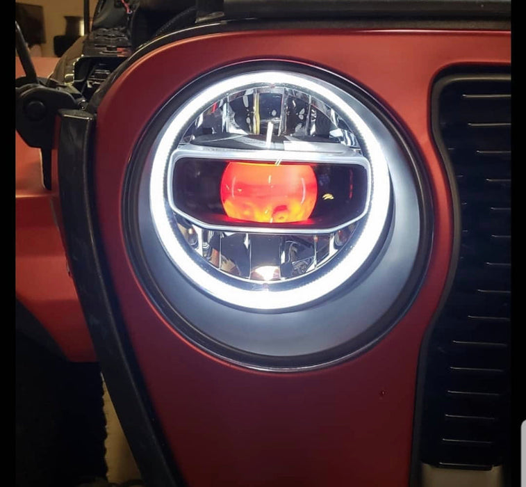 Close-up of jeep headlight with red demon eye projector