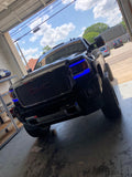 Front end of a GMC Sierra with blue headlight DRLs.