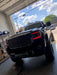 Front end of a GMC Sierra with red headlight DRLs.