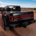 Rear end of a Jeep Gladiator JT with multiple ORACLE Lighting products installed. Including Racetrack LED Tailgate Panel, High Powered Reverse Lights, Flush Mount LED Tail Lights.
