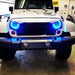 Front end of a Jeep Wrangler with 7" High Powered LED Headlights installed, and cyan halos on.