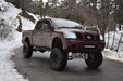 Three quarters view of a Nissan Titan with white LED headlight halo rings installed.