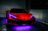 Red Corvette in a garage with purple headlight DRLs.