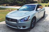 Three quarters view of a Nissan Maxima with white LED headlight halo rings.