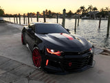 Three quarters view of a Chevrolet Camaro with red headlight and fog light DRLs.