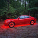 Red Dodge Charger with multiple ORACLE Lighting products installed, including wheel rings, halos, and underbody kit.