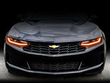 Front end of a Chevrolet Camaro with amber headlight DRLs.