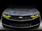 Front end of a Chevrolet Camaro with yellow headlight DRLs.