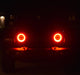 Jeep in the dark with only red halo headlights being visible