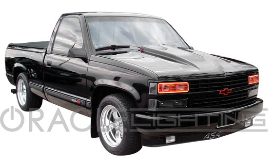 Three quarters view of a black truck with red LED headlight halos.