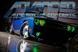 Low aggressive shot of a blue Dodge Challenger with green LED headlight and fog light halo rings installed.