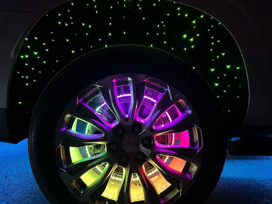 Close up of a wheel well with fiber optic colorshift liner  and LED wheel rings installed.