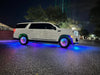 Side view of a white GMC Denali with LED wheel rings and fiber optic wheel liner kit installed.