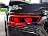 Extreme close-up of a Ram 1500 headlight with red DRLs and red demon eye projectors.