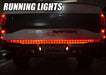 Rear end of a Ford Raptor with 60” Double Row LED Truck Tailgate Light Bar installed and running lights on.