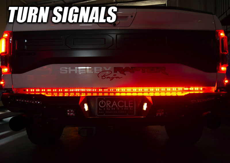 Rear view of a Ford Raptor with 60” Double Row LED Truck Tailgate Light Bar installed and turn signal on.