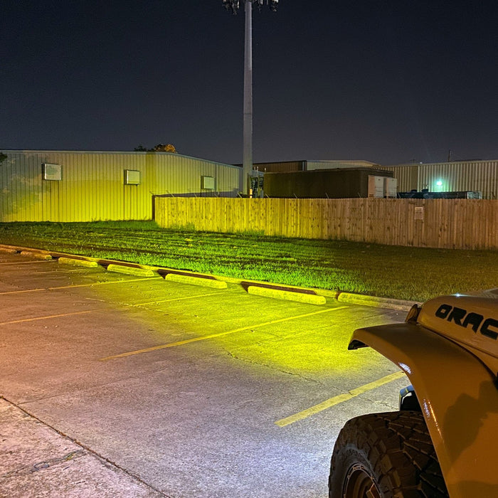 View from the driver's side of a Jeep, showing the light beam from the LED Integrated Skit Plate shining into the distance.