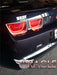 Close-up shot of a dark blue camaro with afterburner tail light halos