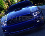 Front end of a Ford Mustang with white LED headlight and fog light halo rings installed.