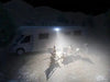 A RV in a desert with the Scene Light illuminating the area next to the RV