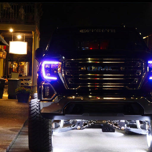 GMC sierra parked outside with purple DRLs