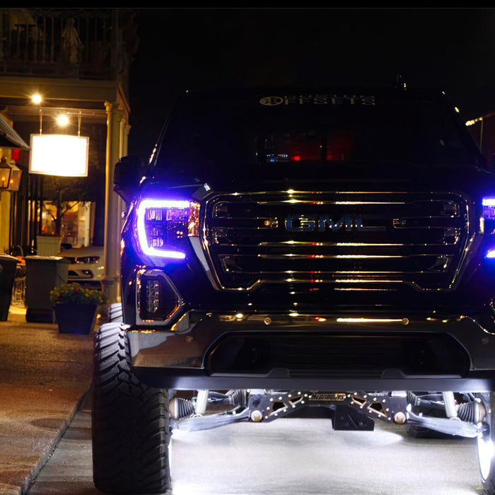 GMC sierra parked outside with purple DRLs