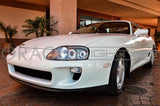 Three quarters view of a Toyota Supra with white LED headlight halos.