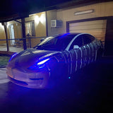 Three quarters view of a Tesla Model 3 with blue headlight DRLs.