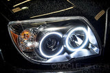 Close-up of a Toyota 4Runner headlight unit with white LED halo rings installed.